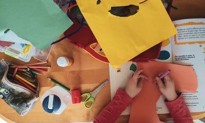 Barn teiknar på farga papir